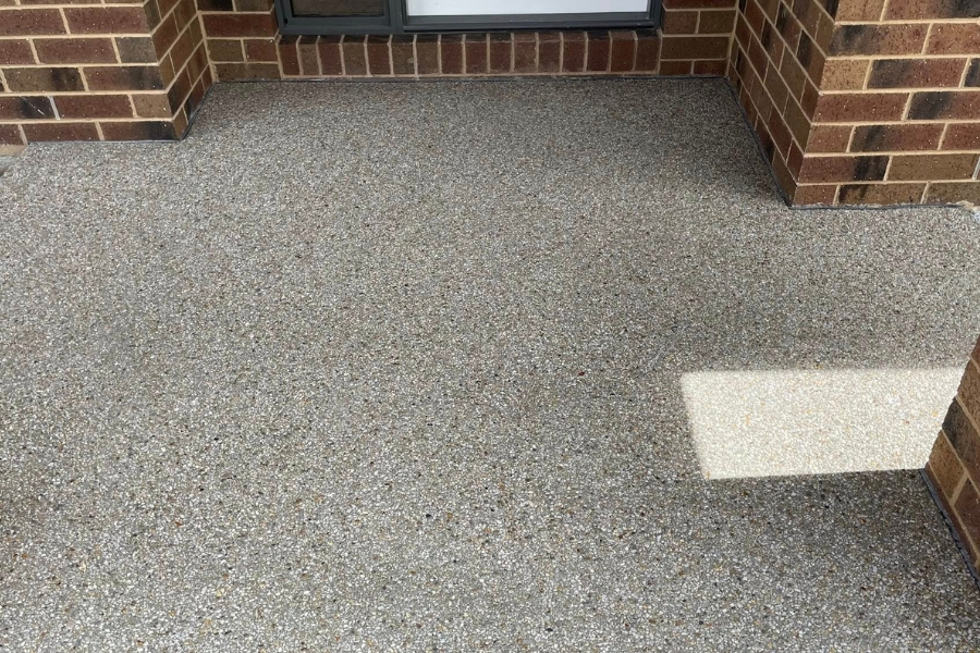 Exposed aggregate alfresco patio finish in the corner of a brick home, Maiden Gully.