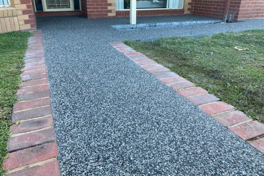 Exposed aggregate pathway with brick paver edging leading to a home, Junortoun.