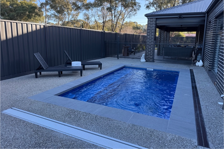 Pool surround poured in exposed aggregate, seen from the alfresco end of a Maiden Gully backyard.