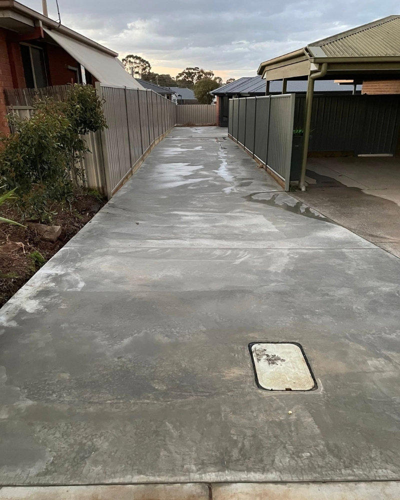 Narrow concrete pathway beside the same unit driveway, running toward the carport, Lockwood.