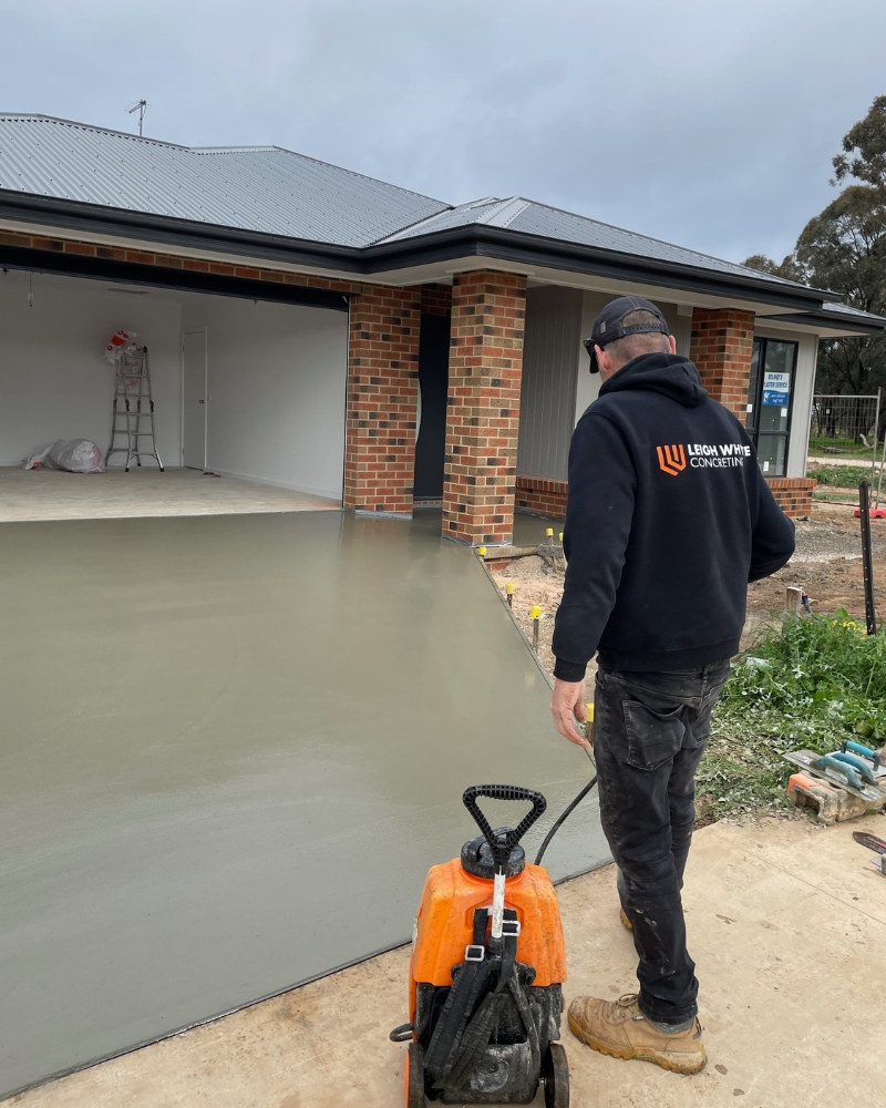 Leigh Whyte Concreting with a washdown tool ahead of the exposing the driveway concrete aggregate, Golden Gully.