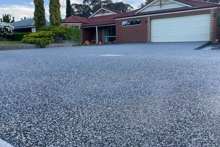 Bold black-and-white exposed aggregate driveway in front of a red-brick Strathfieldsaye home.