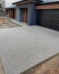 Residential exposed aggregate driveway running alongside a low garden wall, Kennington.