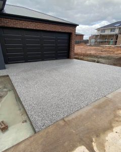 New-build brick home with a finished exposed aggregate surface, construction ongoing next door, Kangaroo Flat.