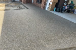 Warm-toned exposed aggregate driveway near a home garage, Strathdale.