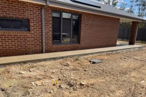 Exposed aggregate path along the base of a heritage red-brick home, Strathdale.