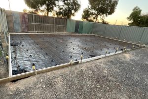 Shed slab prep at sunset with formwork, moisture barrier, mesh and tie-down stirrups in position, Central Victoria.