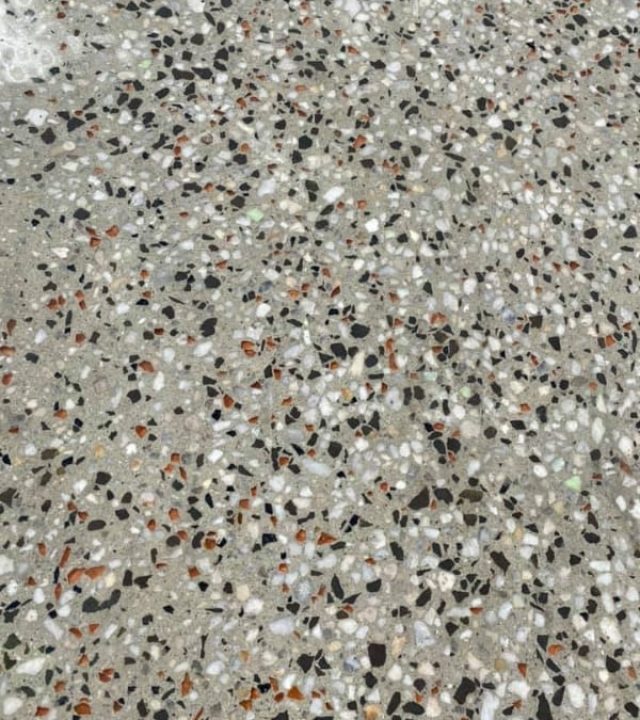 Close-up of an exposed aggregate stone mix with black, white and terracotta stones, Golden Square.